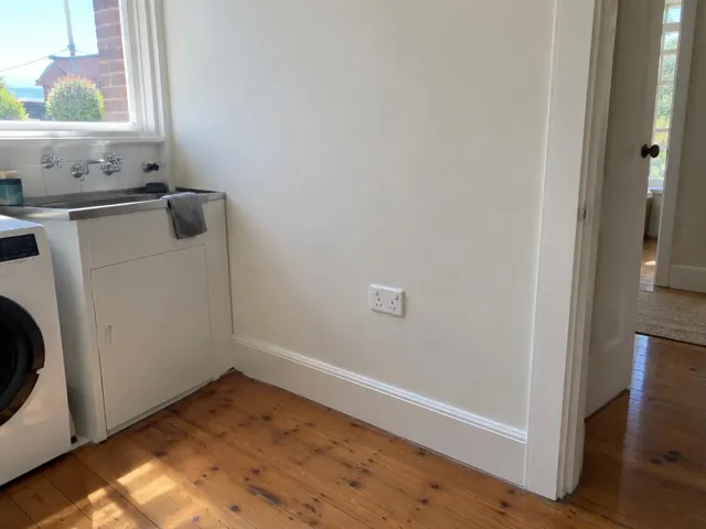 New power point on a painted kitchen wall beside a sink and laundry area in Coogee